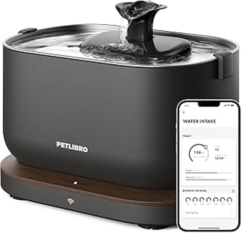 A black pet water fountain with a stainless steel tray and a smartphone app that monitors the water intake.