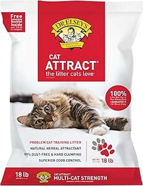 A cat is laying on a bed with a bag of Dr. Elsey's Cat Attract litter.